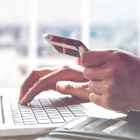 Person with debit card infront of computer